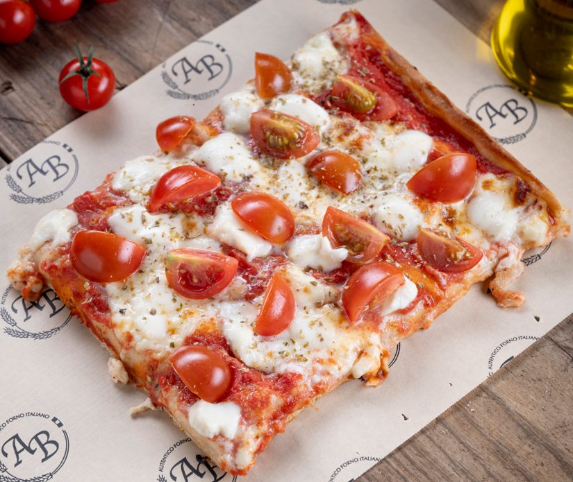Porción de pizza Santa con tomate cherry, mozzarella y orégano